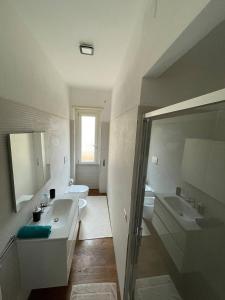 een badkamer met een wastafel, een toilet en een spiegel bij T-Rooms in Cagliari
