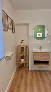 une salle de bain avec un lavabo et un miroir dans l'établissement Le Duplex, 1 chambre, Parking gratuit & Wifi, à Ruelle-sur-Touvre