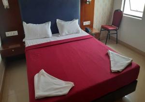 1 cama roja grande en una habitación con silla en Hotel seasons, en Pondicherry