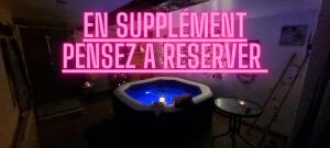 a neon sign in a bathroom with a bath tub at La Manch'hôtes in Domjean