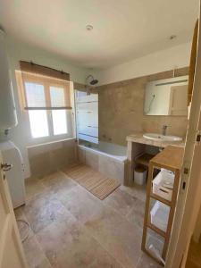 ein großes Bad mit einem Waschbecken und einer Badewanne in der Unterkunft Entre les Alpilles et le Luberon 3 chambres 10 pers in Cavaillon