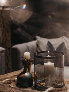 a table with two candles and a candle holder at Hotel Chesa Monte 4Sterne Superior in Fiss