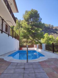 a swimming pool next to a house at El balcón de Cuadros in Bedmar