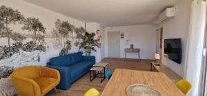 a living room with a blue couch and a table at Appartement avec 5 balcons et parking au cœur de la ville! in Arcachon