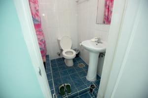 y baño con aseo y lavamanos. en Daora guesthouse en Garapan