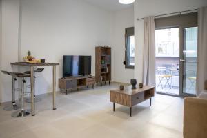 a living room with a tv and a table at Central appartment, Ierapetra in Ierápetra