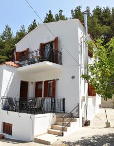 a white house with stairs and a balcony at Maro's house in Samothraki