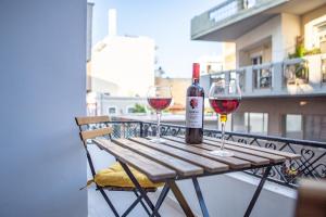 un tavolo in legno con 2 bicchieri di vino sul balcone di Central appartment, Ierapetra a Ierápetra