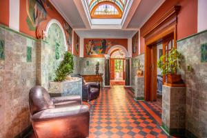 a lobby with leather chairs and a tiled floor at Cape Riviera Guesthouse in Cape Town