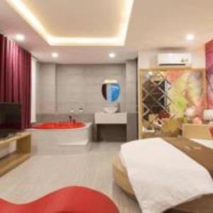 Happy 1 Hotel Binh Duong في Bến Cát: غرفة نوم مع سرير وحوض استحمام في غرفة