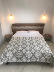 1 dormitorio con cama con colcha gris y blanca en Bafas Apartments, en Plataria