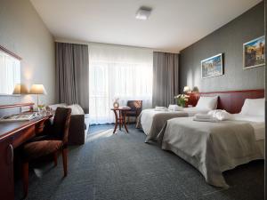 Habitación de hotel con 2 camas y escritorio en Arka Medical Spa en Kołobrzeg