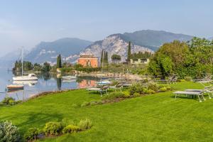 un parque con bancos y una masa de agua en Hotel Val Di Sogno - Adults Only, en Malcesine