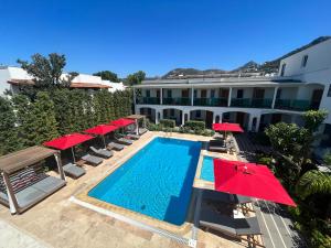 uma piscina com guarda-sóis e um hotel em The Losh Hotel em Yalıkavak