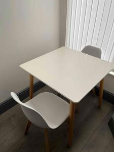 a white table and a white chair sitting next to a window at Complete 4 Bedroom House in Hanley-Free Parking in Hanley