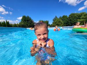 Ein kleines Mädchen im Wasser im Pool. in der Unterkunft Bieszczadzki Ośrodek Wypoczynkowo Konferencyjny DANFARM in Ustrzyki Dolne