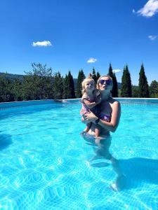 a woman holding a child in a swimming pool at Bieszczadzki Ośrodek Wypoczynkowo Konferencyjny DANFARM in Ustrzyki Dolne