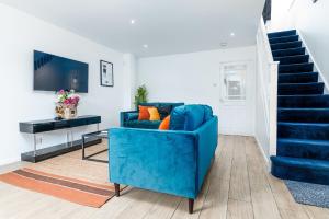 eine blaue Couch in einem Wohnzimmer mit einer Treppe in der Unterkunft Marham Close in Nottingham