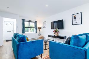 a living room with two blue chairs and a tv at Marham Close in Nottingham