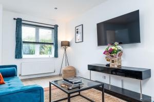 a living room with a blue couch and a tv at Marham Close in Nottingham