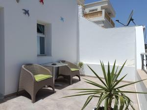 een patio met stoelen, een tafel en een plant bij Residence Debbabi in Monastir