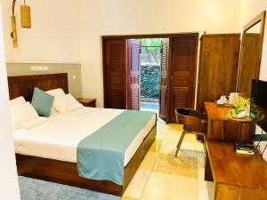 a bedroom with a bed and a desk and a television at Grand Rockland Hotel in Matara +59 photos