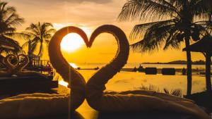 a pair of swans forming a heart at a beach at Sasitara Thai Villas in Choeng Mon Beach