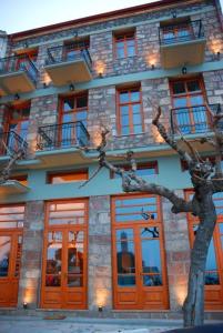un edificio con un árbol delante de él en Hotel Parnassos, en Arachova
