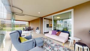 a living room with a couch and a table at Modern flat with beautiful outdoor space in Le Mont-sur-Lausanne