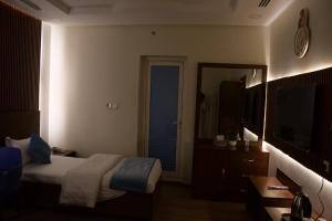 een hotelkamer met een bed en een spiegel bij فندق ايلاف الشرقية 2 Elaf Eastern Hotel 2 in Sayhāt