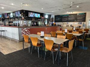 a restaurant with tables and chairs and a bar at Jurien Bay Hotel Motel in Jurien Bay