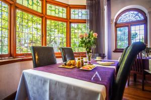 una sala da pranzo con tavolo e tovaglia viola di Cape Riviera Guesthouse a Città del Capo