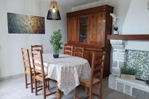 a dining room with a table and chairs and a fireplace at Au bois dormant in Pont-du-Casse