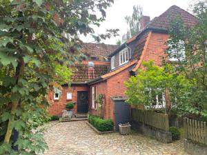a brick house with a driveway in front of it at Ferienwohnung Alte Scheune in Egestorf