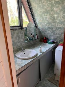 uma casa de banho com um lavatório e um espelho em Leśny domek em Koronowo