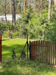 una valla de madera en un patio con un campo en Leśny domek, en Koronowo