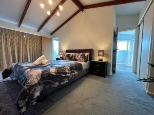 a bedroom with a large bed and a window at The Airport Homestay House in Christchurch