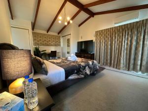 Un dormitorio con una cama y una mesa con una botella de agua. en The Airport Homestay House, en Christchurch