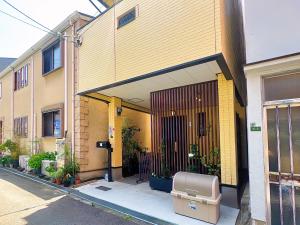 大阪千間川-緑橋的一座黄色建筑,前门有植物