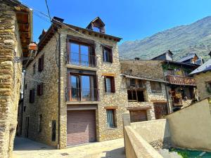 un antiguo edificio de piedra con garaje en Dúplex amb encant al casc antic d'Esterri i vistes úniques by RURAL D'ÀNEU, en Esterri d'Àneu