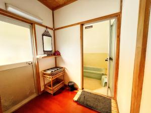 een badkamer met een spiegel en een badkamer met een bad bij Iriyama-So in Shimoda