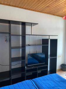 una camera da letto con un letto e una TV a parete di Hotel Aurora a Ureki