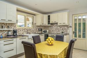 kuchnia ze stołem z krzesłami i żółtą tkaniną w obiekcie Bay Lodge Alykanas w Alikanás