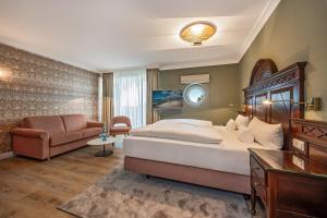 a hotel room with a bed and a couch at Strandhotel Heringsdorf in Heringsdorf +74 photos