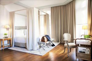 a hotel room with a bed, chair and a desk at URSO Hotel & Spa, a Small Luxury Hotel of the World in Madrid