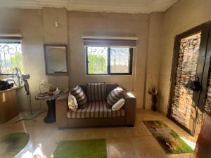 a living room with a couch and two windows at Oak Chalet شاليه الملول 