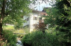 ein Gebäude mit einer Brücke und einem Fluss davor in der Unterkunft Ferienhaus Signina in Danis