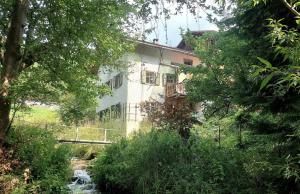 a building with a bridge and a river in front of it at Ferienhaus Signina in Danis