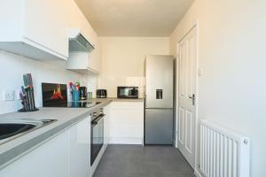 cocina blanca con fregadero y nevera en 2 Bedroom house in Bradley Stoke- Hopewell, en Bristol