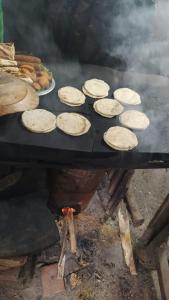 a bunch of pies cooking on a table with a grill at Pahiyan huts 